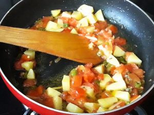 potatoes with tomato in pan