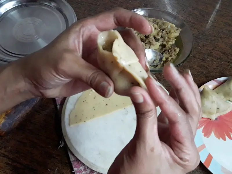 press the edges to seal the corners of samosa