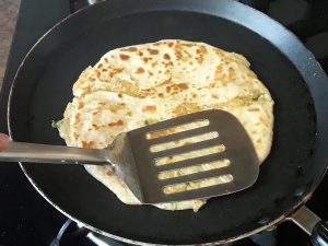 press paratha to cook it from both sides
