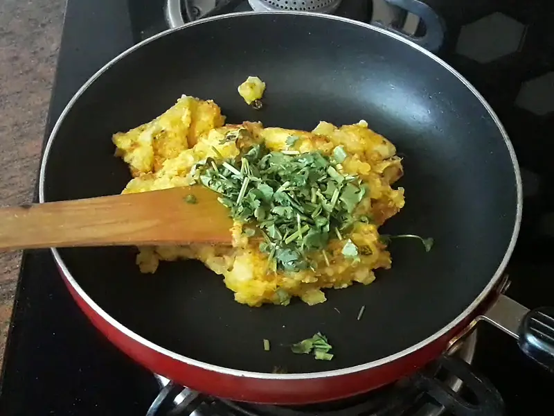 chopped coriander in the potatoes