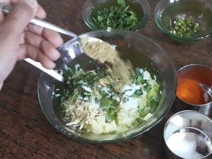 coriander powder in grated potatoes