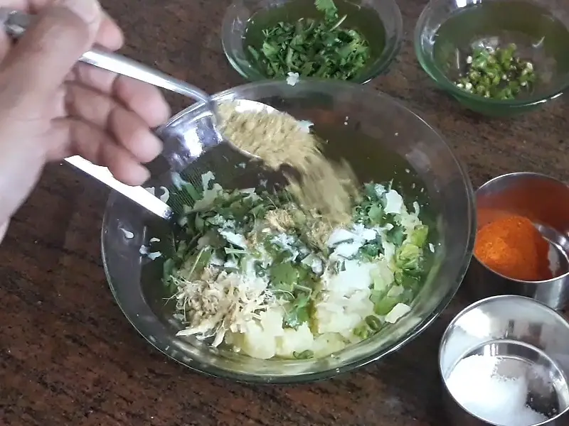 coriander powder in grated potatoes